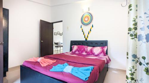 西奥利姆Poolside Paradise 1Bhk Luxury Apartment in Siolim.的一间卧室配有一张带粉红色和蓝色床单的床