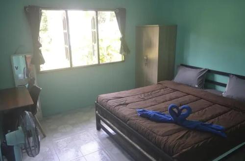 Khlaung Phai BaeThe Lion House的一间卧室配有一张带蓝色丝带的床