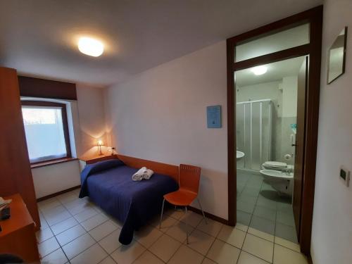 ChiusaforteAlbergo Martina的一间卧室配有一张床,浴室设有卫生间