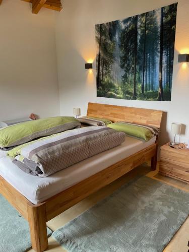 法尔先特Dachgeschosswohnung mit traumhaftem Zugspitzblick bei Garmisch的一间卧室配有一张木床,墙上挂有绘画作品
