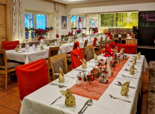 法克湖Gasthaus - Pension Kärntnerhof的用餐室配有白色的桌子和红色的椅子