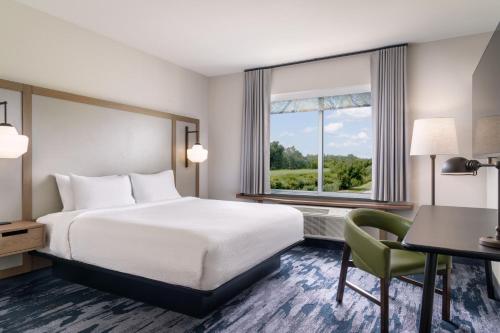 BrooklynFairfield Inn & Suites by Marriott Cleveland Tiedeman Road的配有一张床、一张书桌和一扇窗户的酒店客房
