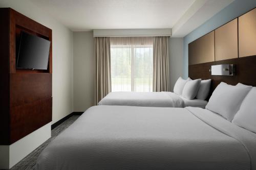 绿湾格林湾中心万豪原住客栈的酒店客房设有两张床和电视。
