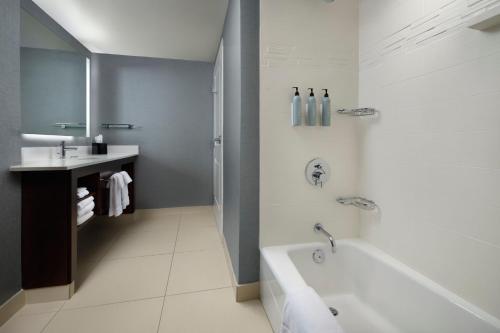 绿湾格林湾中心万豪原住客栈的白色的浴室设有浴缸和水槽。