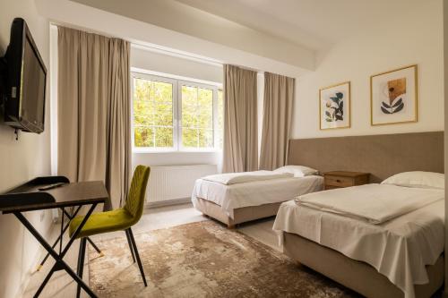 波亚纳布拉索夫Monterai Resort的一间卧室配有两张床、一张桌子和一台电视。