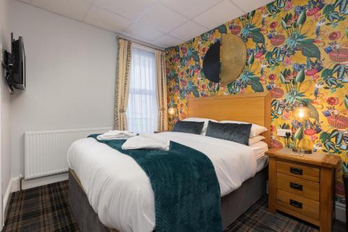 布莱克浦Adelaide Lodge - Town Centre - Opposite Winter Gardens的一间卧室配有一张床和华丽的壁纸