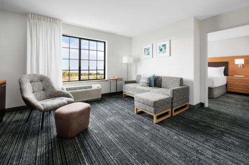 罗斯威尔TownePlace Suites by Marriott Roswell的酒店客房配有一张床、一把椅子和一张沙发