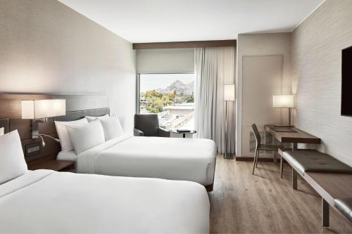 凤凰城AC Hotel Phoenix Biltmore的酒店客房配有两张床和一张书桌
