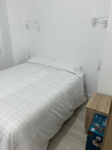 马德里Moncloa apartment, con parking的卧室配有白色的床和木桌