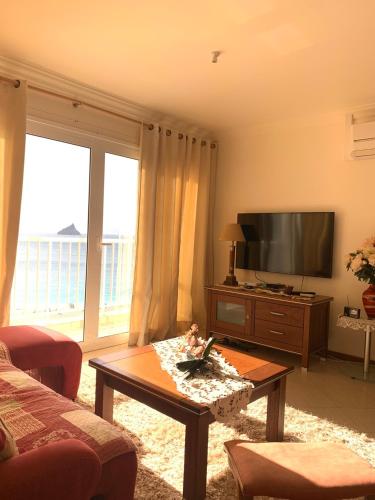 明德卢Laginha Beachview的客厅配有电视和茶几