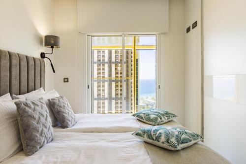 贝尼多姆Intempo Residential Sky Resort & Spa - Benidorm, España的一间卧室设有一张大床和大窗户