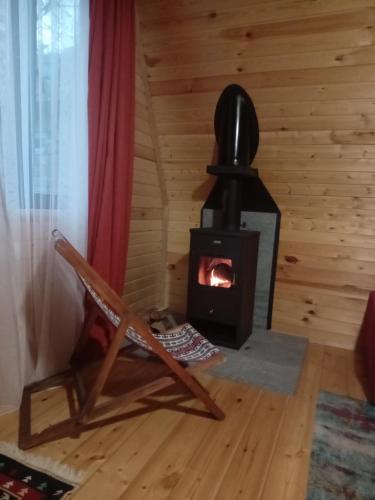 梅斯蒂亚Cottage Mida的一个带椅子的客房内的燃木炉
