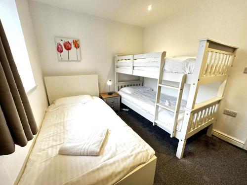 基德灵顿Maisy Lodge - Two Bed Lux Flat - Parking, Netflix, WIFI - Close to Blenheim Palace & Oxford - F2的一间卧室设有两张双层床和一扇窗户。