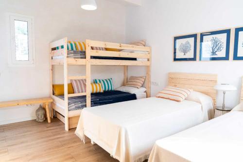 桑特柳伊斯VILLA BINISABEL NOU, CONFORT Y EXCLUSIVIDAD的一间卧室配有两张床和一张双层床。