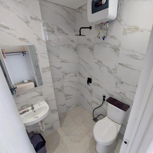 万隆Rumah Gaharu的白色的浴室设有卫生间和水槽。
