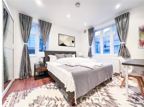 伦敦Central London Apartment Camden的一间卧室设有一张床和两个窗户。