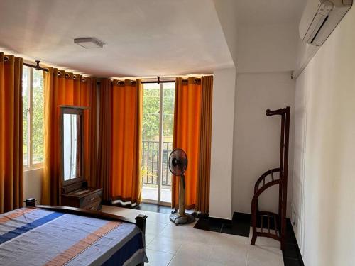 马哈拉贾马2 Bedroom Apartment - Aurora Residences Maharagama的一间卧室配有橙色窗帘、一张床和窗户