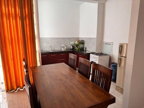 马哈拉贾马2 Bedroom Apartment - Aurora Residences Maharagama的带木桌和椅子的厨房以及带冰箱的厨房。