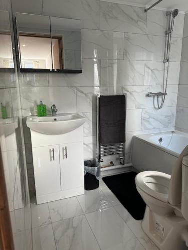 卢顿Luton Home near Airport Private & Shared Bathroom Option的白色的浴室设有水槽和卫生间。