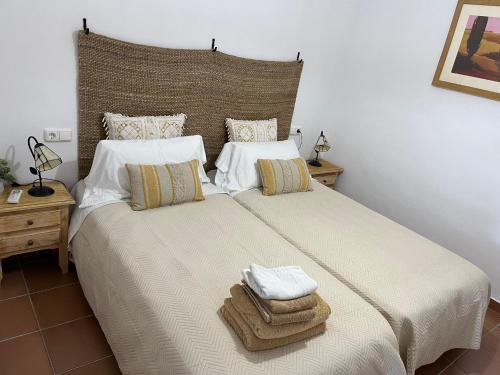 阿尔加德萨Apto. Residencial La Alcaidesa的一间卧室配有一张大床和毛巾