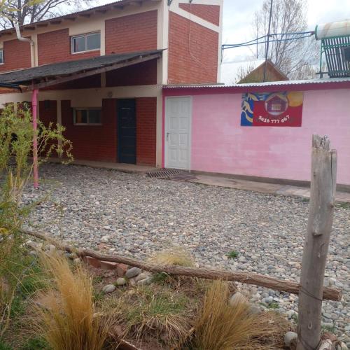 马拉圭dormi La familia的粉红色的建筑,前面有栅栏