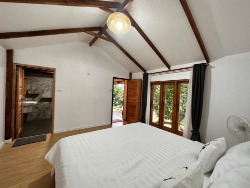 湄宏颂Jungle guest house的一间带白色大床的卧室和一间浴室
