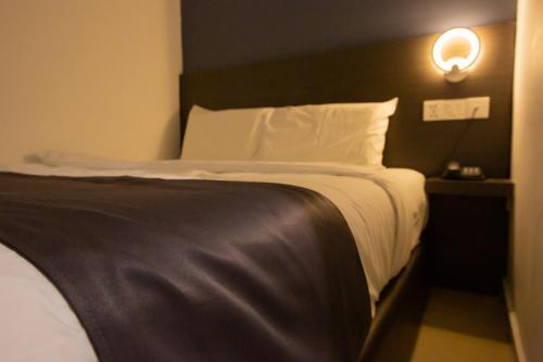 波德申1 Hotel Signature的一张位于酒店客房的床铺,墙上有灯