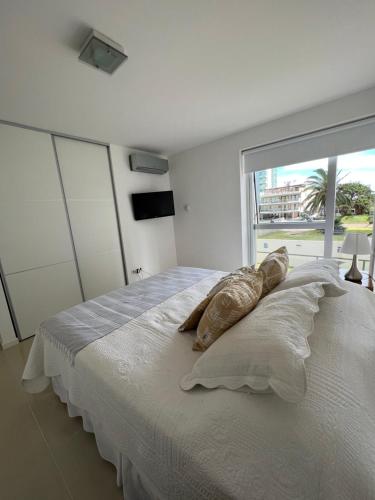 埃斯特角城Arenas del Mar Punta del Este的一间卧室配有一张带枕头的床