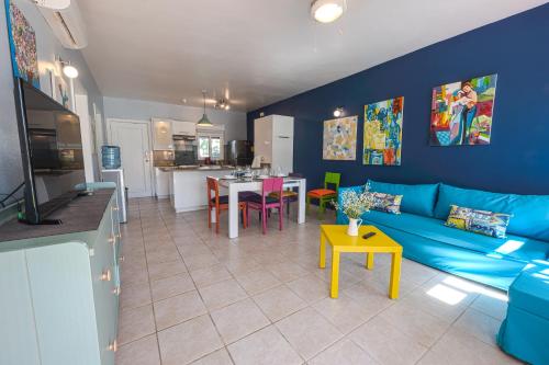 蓬塔卡纳Stanza Mare Beach Front的客厅配有蓝色的沙发和桌子