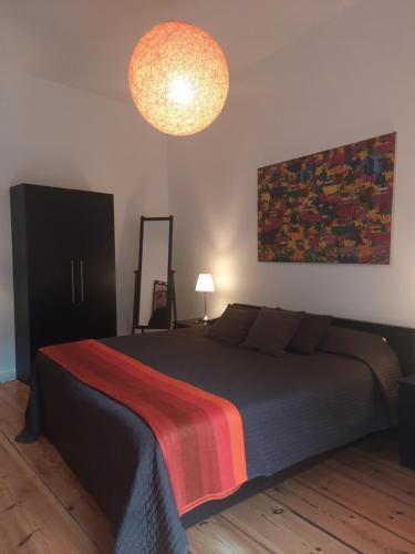 柏林Berlin Apartments Mitte的一间卧室配有一张带彩色毯子的床