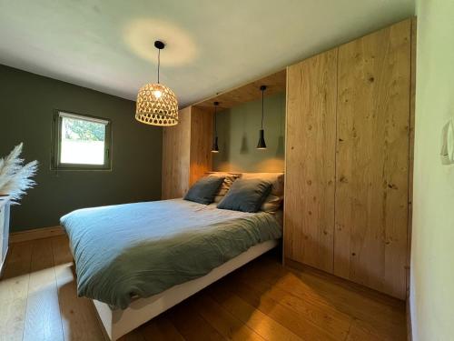 圣莫里斯堡Grand chalet à la montagne的一间卧室配有一张带大型木墙的床。