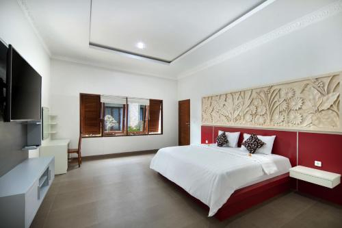库塔Jineswari Kuta by Kamara的一间卧室配有一张大床和一台平面电视