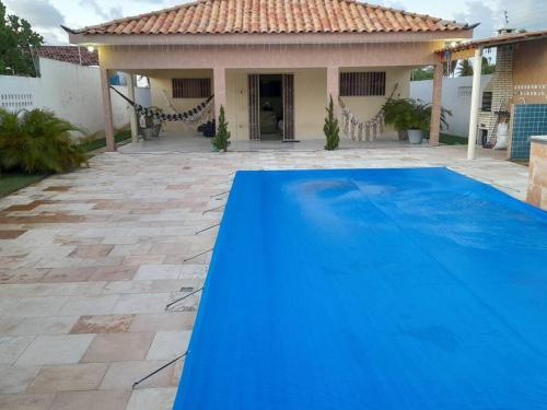 卢塞纳Bela casa de Veraneio - faça sua reserva.的房子前面的蓝色游泳池