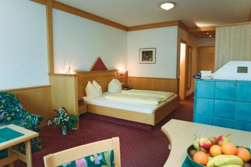 文斯伽斯特霍夫皮特塔尔霍夫酒店的酒店客房,配有一张床和一张桌子,还有一碗水果