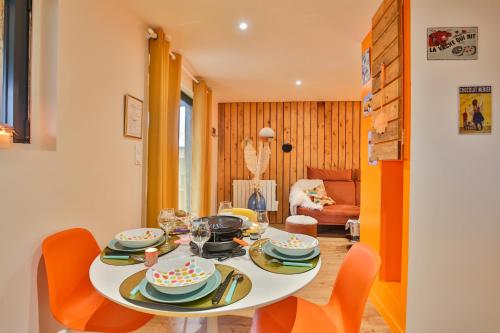 Clermont-CréansCHALET VINTAGE - Les Belles Ouvrières的一间配备有白色桌子和橙色椅子的用餐室
