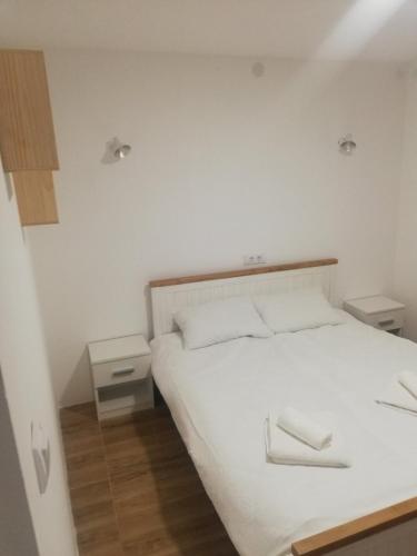皮罗特Vila Budimir的一间卧室配有白色床和2个床头柜