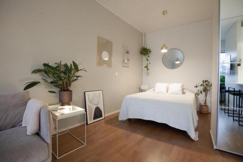 赫尔辛基Luxury Nordic Loft with Great Kitchen and Location的白色卧室配有床和沙发