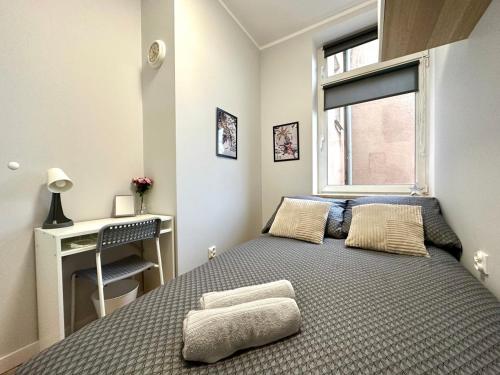 格但斯克MMRent Tiger Room的一间卧室配有一张床、一张书桌和一个窗户。