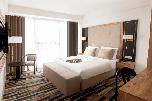 安卡拉Shelter Inn Hotel & Spa的卧室配有一张白色大床和一张书桌