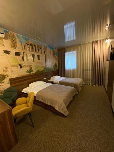 波尔塔瓦Status Hotel的酒店客房,配有两张床和椅子