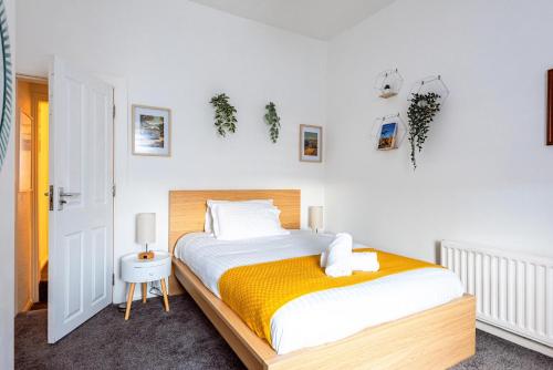 雷克瑟姆3 bedroom House - Next to Wrexham FC Racecourse Stadium的一间卧室配有一张带黄色毯子的大床
