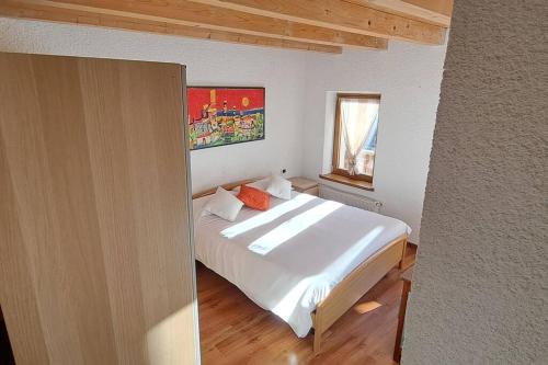 皮耶韦迪卡多雷In cima alla contrada的卧室配有白色的床和窗户。