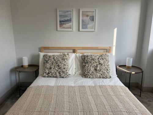 浦耳Contemporary, stylish south coast home的一间卧室配有一张带两张边桌的床