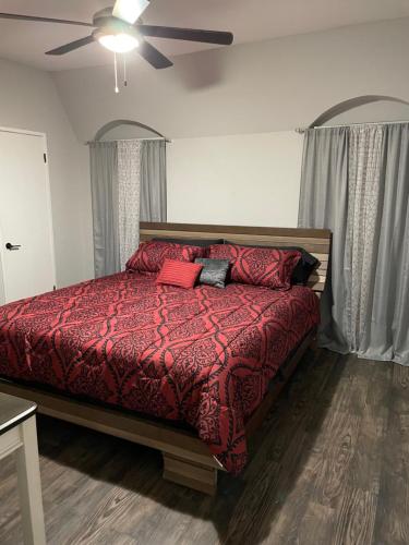 休斯顿Rafeal的一间卧室配有一张红色棉被的床