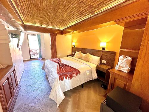 瓜纳华托Suites del Jardín Principal的一间卧室设有一张带木制天花板的大床