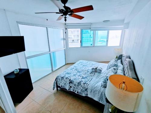 巴拿马城Punta Pacífica Oceanfront apartment的一间卧室配有一张床和吊扇