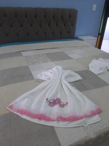 伊列乌斯Pousada Bem Te Vi的床上的白色毯子,粉红色和白色