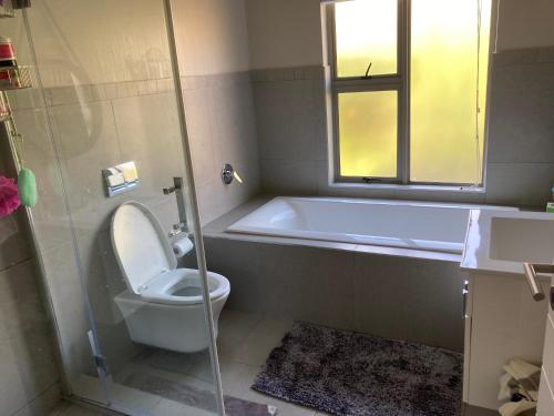 巴利托Zimbali Wedge的一间带卫生间的浴室和一个带窗户的浴缸