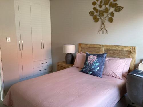 巴利托Zimbali Wedge的一间卧室配有一张带粉色床单和枕头的床。