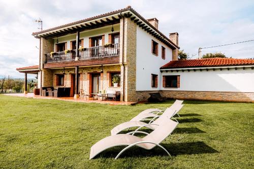 奥维多Villa Tiviti的房子前面草上一群白色的躺椅